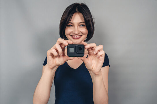Positive emotions from photography. Woman with camera. Gopro. Action camera. - Powered by Adobe