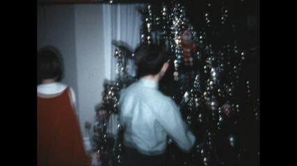 Decorating the Tree 1970 - Siblings finish decorating the family Christmas tree at their home in Vernon Township, New Jersey in 1970. - Powered by Adobe
