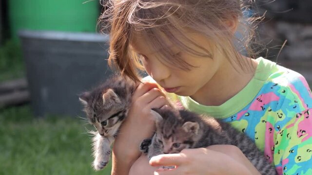 Little girl with kittens in hands
