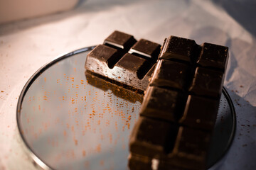 A bar of dark chocolate lies on the paper