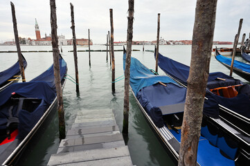 Fototapeta na wymiar Empty gondolas swing on water, Venice, Italy