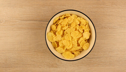 Top view of breakfast cereal in round plate on wooden table