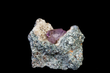 macro mineral amethyst stone in rock on a black background