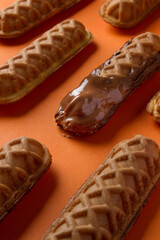 waffle sticks glazed making patterns. orange background
