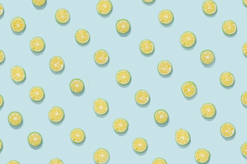 Candy hard bombon slice lime fruit pattern against pastel blue flat lay composition.