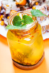 Sea-buckthorn tea with orange, kumquat and mint on orange paper background