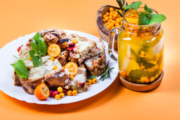 Sea-buckthorn tea with orange, kumquat and mint on orange paper background