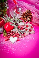 Bright Christmas decorations with fresh cranberries on a paper crimson background.