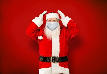 Fototapeta na wymiar Real Santa Claus with a red background, wearing a protective mask, glasses and hat.