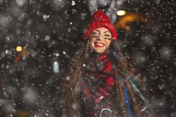Fototapeta na wymiar Wonderful lady enjoying snowy weather at the holiday fair