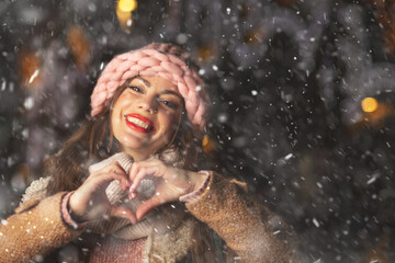 Obraz premium Cheerful lady in gloves enjoying snowfall