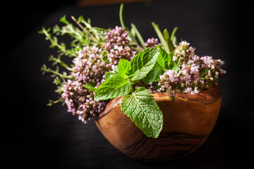 Fresh herb oregano flowers in a wooden bowl