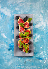 Fresh figs with mint leaves and blackberry. Flat lay, Copy space. Vegetarian food. Healthy diet.