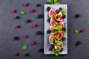 Fresh figs with mint leaves and blackberry. Flat lay, Copy space. Vegetarian food. Healthy diet.