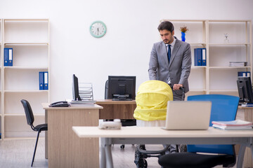 Young male employee looking after new born at workplace