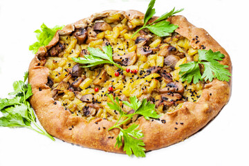 Pie with stewed potatoes and mushrooms on black background