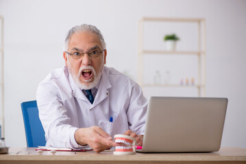 Obraz premium Old male doctor dentist working in the clinic