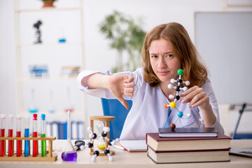 Young female chemist student studying molecular model
