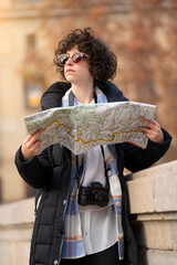 Young tourist woman searching in the city with a map