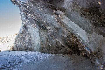Oktyabrskaya cave of the Bogdanovich glacier in Kazakhstan. View from within and blue cloudy sky.