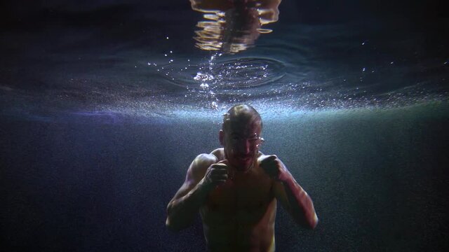 amazing underwater portrait of fighting boxer, slow motion shot of agressive man