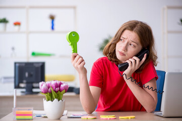 Young female designer holding big key in the office