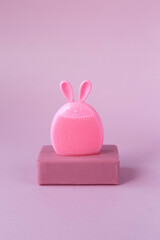 Natural pink soap, silicone sponge on a pink background