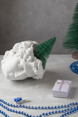 Plaster copy of the head of David with a Christmas tree, balls, beads on a light background. New...
