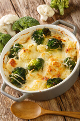 Casserole of broccoli, cauliflower and cheese in a baking dish close-up on the table. Vertical