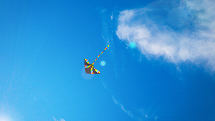 Kite background. Colorful high flying toy. Air kite fly on blue wind sky. Rainbow kite in summer...