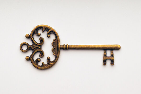 Single antique key on a white background.