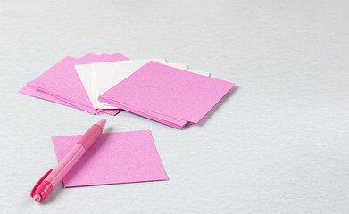 pink and white note paper with pink pen on gray desktop. Stick notes for single or important events


