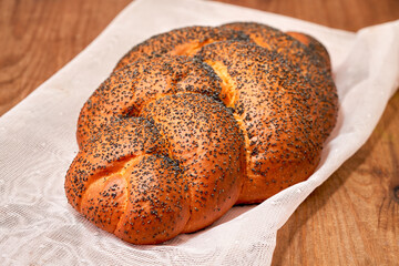 Challah with sesame seeds on wooden background