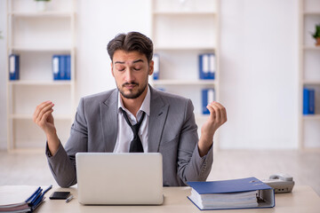 Obraz premium Young male employee working in the office