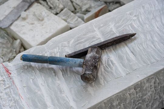 Sculptor tools on a marble slab, close up. Workplace, traditional tools sculptor, red chalk, ruler, hammer and chisel for working stone. Vietnam