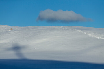 A skier in the snow with cloud