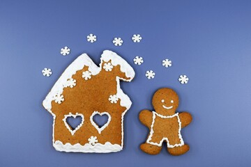 Romantic gingerbread house, smiling man and falling snowflakes. Christmas or winter time