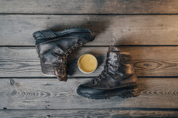 Leather outdoor shoes or boots with maintenance Set on wood background. Outdoor boots with wax. Waxing and cleaning outdoor shoes.