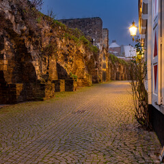 A typical cobble stone alley in the center of Maastricht, winding alongside a 800 years old city defense wall built from limestone taken from the local quarries. 