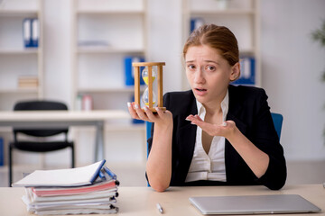 Young female employee in time management concept