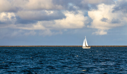 Fototapeta premium Sailboat sailing in the calm waters of Hilo Bay on Big Island, Hawaii