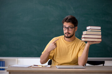 Young male student preparing for exams in the classroom