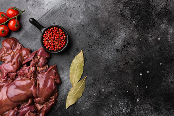 Raw liver chicken offal meat, on black dark stone table background, top view flat lay, with copy space for text - obrazy, fototapety, plakaty