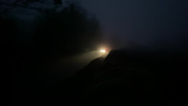 car headlights lights  in mist fog at night uk road sigh silhouette