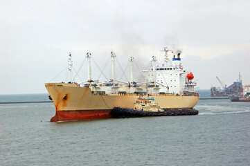 Tugboat assisting bulk cargo ship