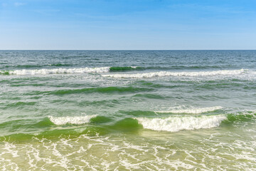 Fototapeta na wymiar Seascape with incoming waves on the sandy shore.