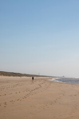 Fototapeta na wymiar Single person walking at the beach