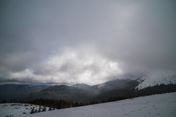 Winter mountains with snow under a dark winter sky.