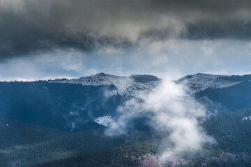 Fototapeta na wymiar Winter mountains with snow under a dark winter sky.