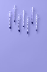 Syringes in flat lay style toned in trendy color of year 2022. Cosmetology and medicine background. Vaccine concept. Flat lay style.